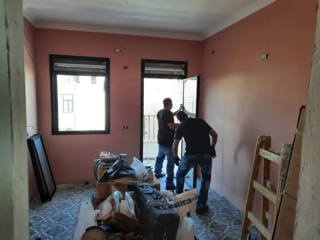 צוות השיפוצים של וסים אבו נאג'י בעבודה בחדר עם קירות ורודים