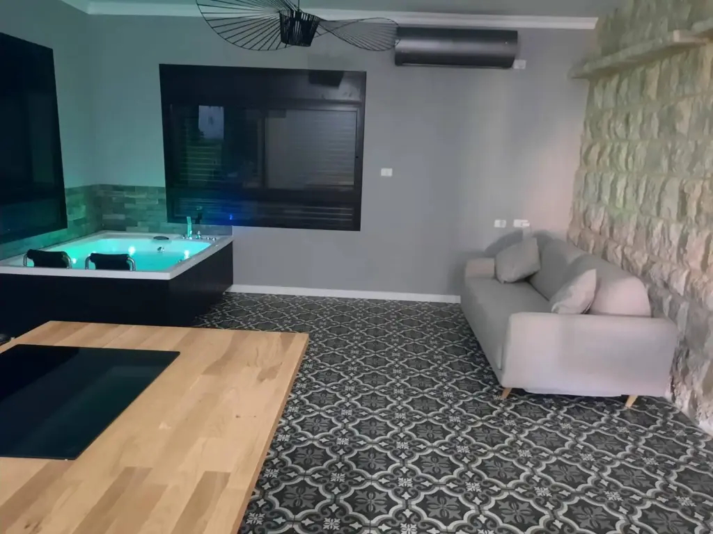 סלון משופץ עם ג'קוזי, ספה, קיר אבן דקורטיבי וריצוף מצויר